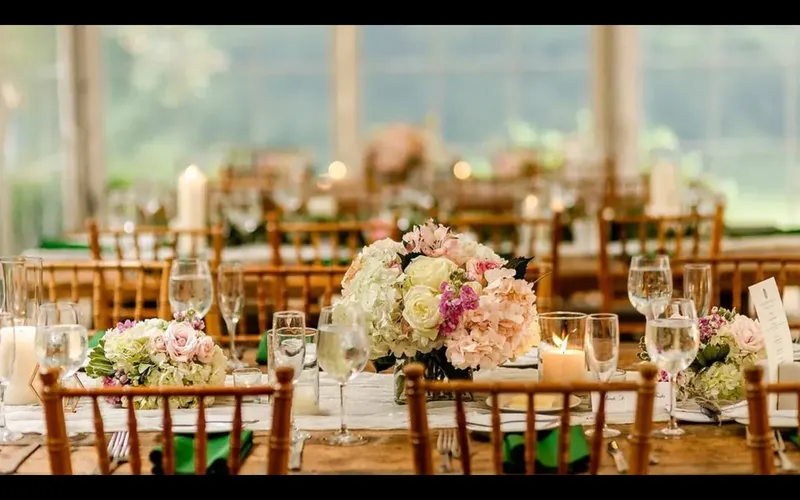 Mesa de evento servida con platos de porcelana, copas de cristal y cubiertos metálicos