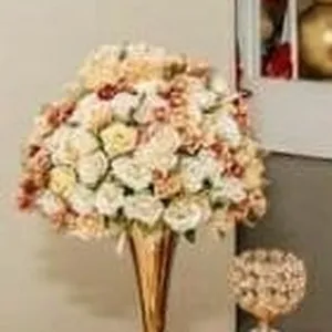 Centros de mesa con jarron dorado y eucalipto. rosas. espidida. flor en forma de espiga y plumillas